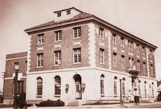 Sepia tone image of three story brick building