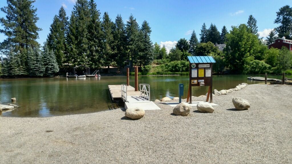 Image of sandy shore with boat dock leading into lake